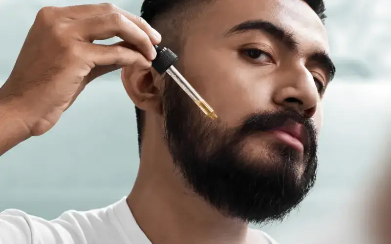 Bearded Man Applying Baerd Oil on His Beard